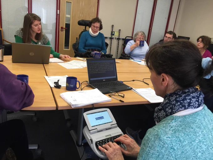 An in-person engagement meeting with members sat around a board table