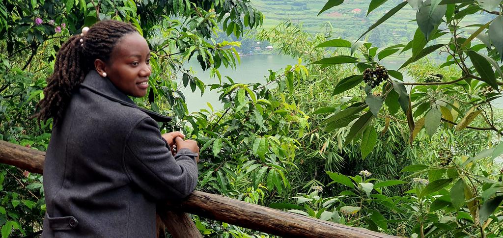 👑 Embracing the serenity of Lake Bunyonyi 🌳🏞️ Through lush trees and vibrant shrubs, the Miss Kigezi Tourism Queen gazes upon the breathtaking vista, captivated by nature's majesty. 🌿✨ #LakeViews #NatureEscape #HawksEyeLodge 🦋 #Misstourism #ExploreUganda #visitkigezi