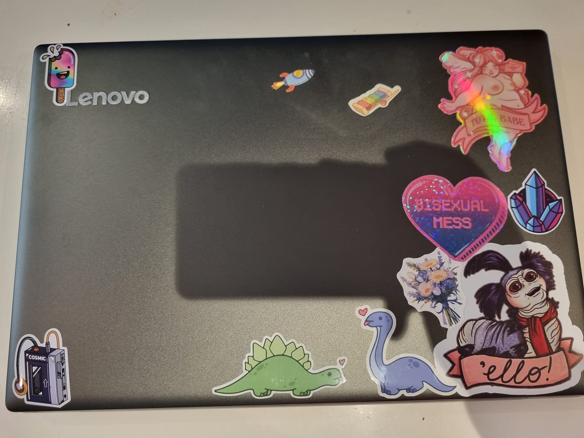 pandoratolson's tweet photo. I inherited Mr Geeks old laptop, so after removing the Bandit Heeler, and Bluey stickers, and rechristened the laptop to the Chilli Bin, new stickers were required. 
Now to write the rest of Tessa, and HW on it <3 #amwriting  #Lenovo #AuthorLife https://t.co/lFf969xEUg
