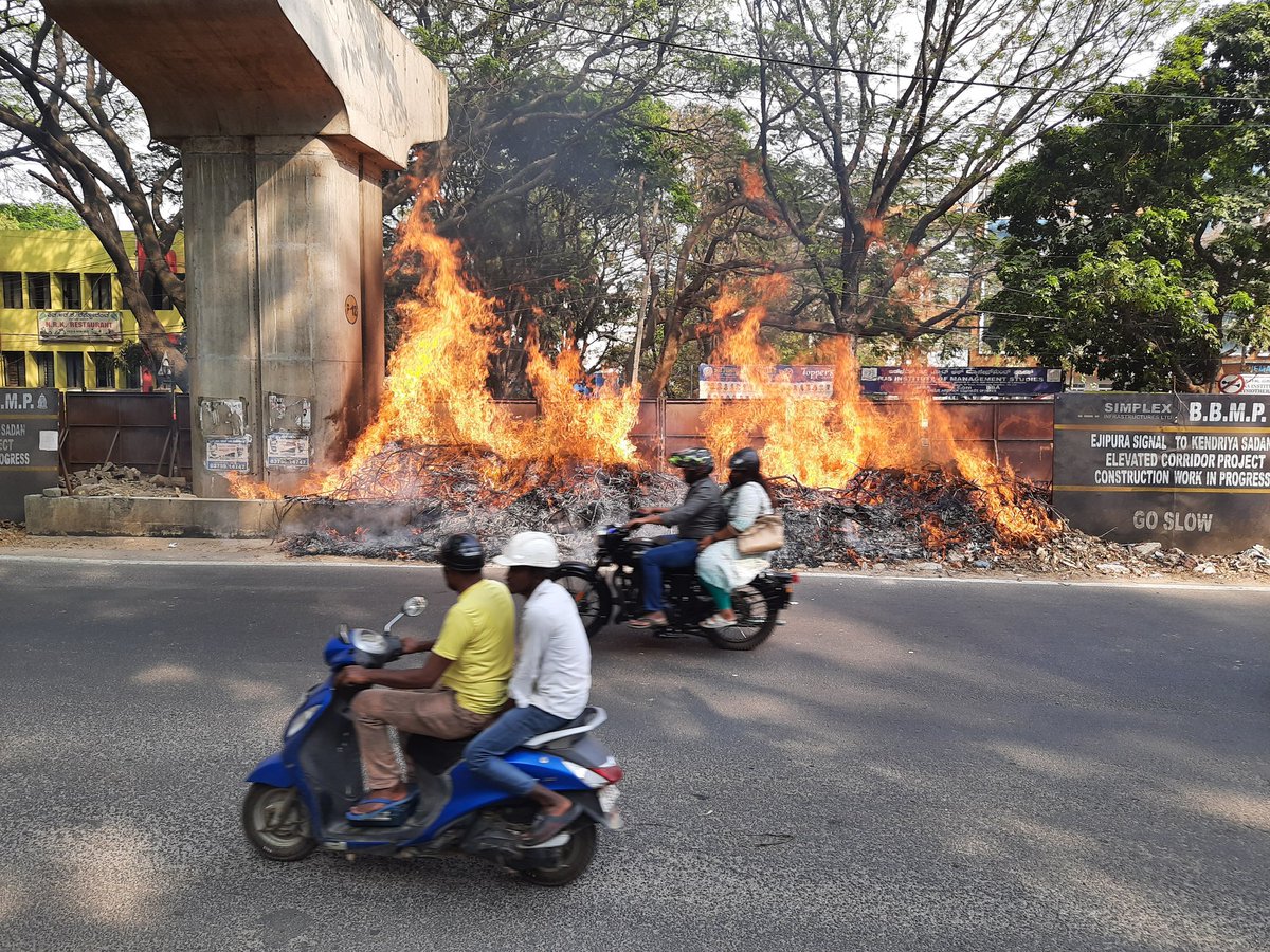 Ananthaforu's tweet photo. The chopped tree branches left under monumental Ejipura flyover (unfinished) caught fire just now. 

@KarFireDept maybe you can ask @BBMPCOMM team to clear this debris before something major happens. https://t.co/UBqSNujDCe
