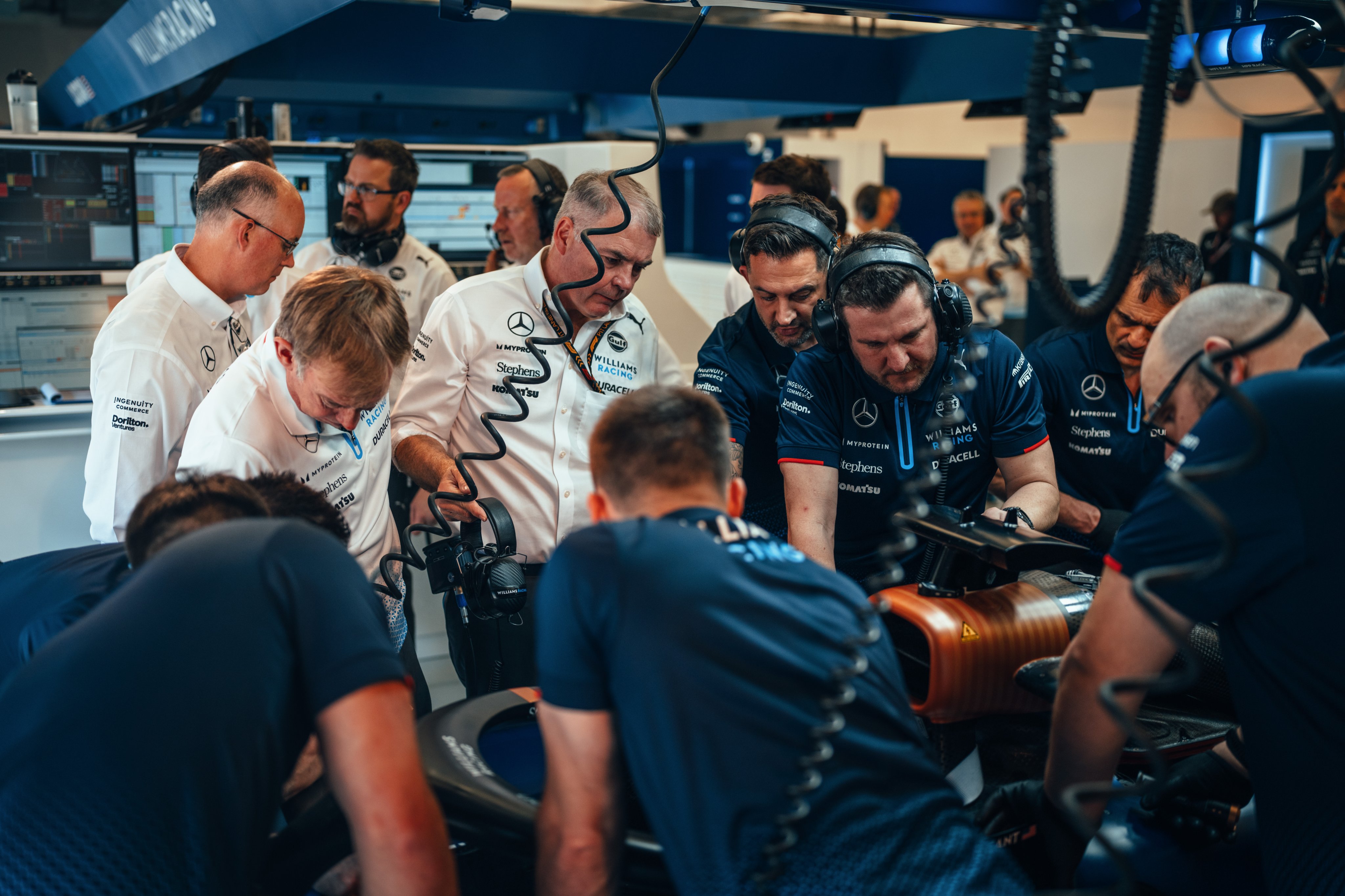 Mechanics and engineers work on the FW46.