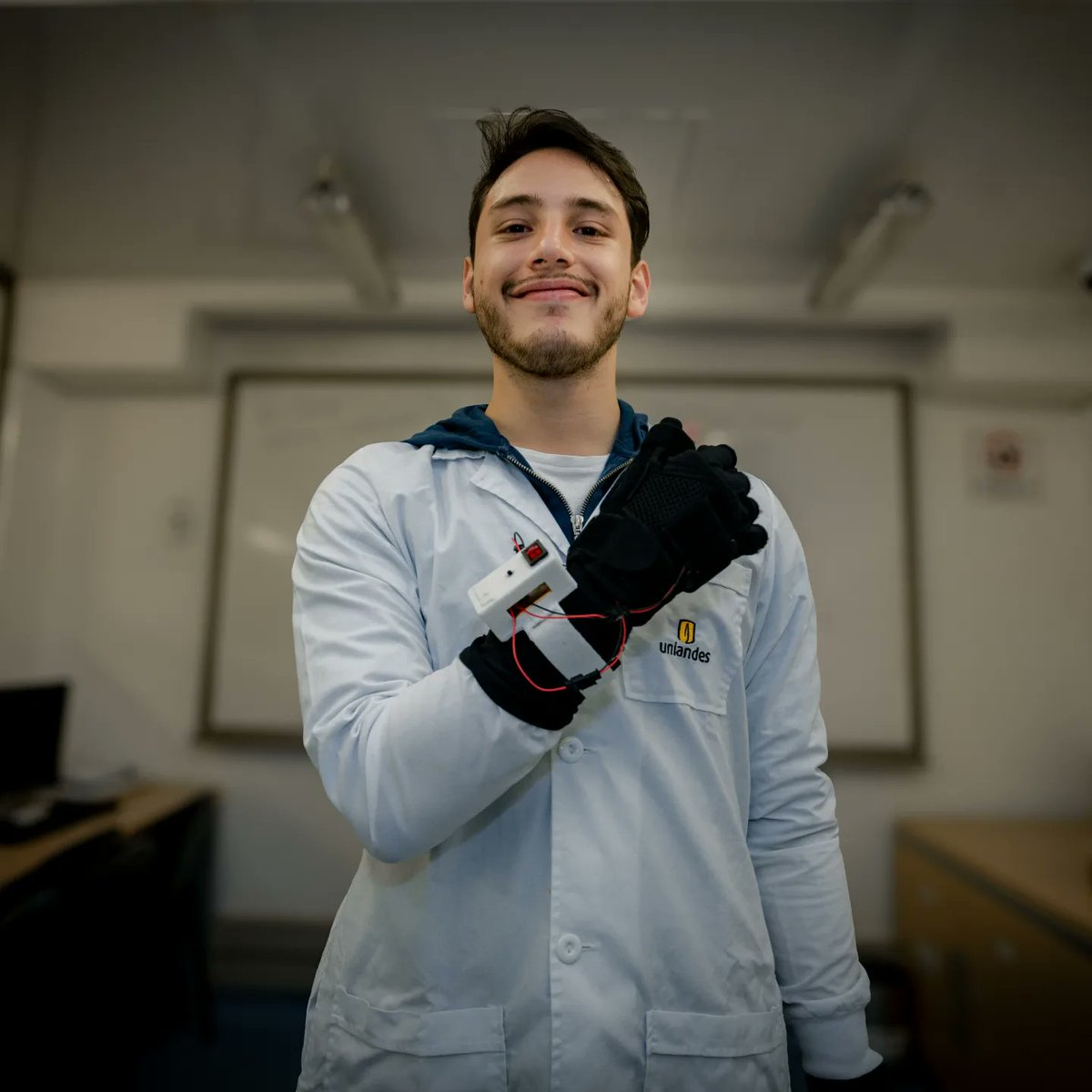 Uniandes's tweet photo. Imagina despertar un día y sentir un temblor incontrolable en tus manos que no te deja ni siquiera servir una taza de café. Te presentamos a Santiago Martínez, quien, impulsado por su propia dificultad, desarrolló un guante que ayuda a reducir el temblor esencial, una enfermedad que afecta a 616 de cada 100 mil personas. 

✋🏻😤“Yo llego al laboratorio e intento pesar algo con las herramientas de siempre y me doy cuenta de que no puedo parar de temblar”.

🏥✖️Santiago es estudiante de último semestre de Ingeniería Biomédica, tiene 23 años, y fue diagnosticado con un trastorno del sistema nervioso que se caracteriza por movimientos involuntarios. Hasta la fecha, no se conoce una solución definitiva. 

🤜🏻🤛🏻Frente a este panorama, junto a su amigo y compañero de clases, Germán Reyes, crearon ART - Regulador Autónomo del Temblor. “Yo esperaba que mis compañeros me dijeran que la idea era absurda. En lugar de eso, me dijeron: 'Hágale, cuente con nosotros'", cuenta Santiago.

🧤👩🏻‍💻Se trata de un prototipo de guante inteligente que, a través de presiones selectivas y microvibraciones en algunos músculos y tendones, ayuda a controlar el temblor en áreas específicas y a contrarrestar el movimiento inercial de la mano. 

😱Según los estudiantes, ART podría reducir o eliminar el temblor esencial, así como las vibraciones asociadas al parkinson y otros trastornos del movimiento. “Siempre recordaré el rostro emocionado de una paciente que sufrió temblores durante 50 años. Se sorprendió al observar que con el simple acto de ponerse el guante se detuvo el padecimiento con el que había luchado durante tanto tiempo”, cuenta Santiago. 

🤩El proyecto ha despertado tanto interés que Santiago ha sido aceptado en la convocatoria Star Fellowship de la Universidad de Saint Gallen (Suiza), para participar en una inmersión práctica en un programa de mentoría y aceleración de emprendimientos de renombre mundial. 

“Sería muy feliz viendo una versión más avanzada del guante en manos de los pacientes que nos colaboraron, así como de otras personas que enfrentan ese problema”, anhela Santiago.