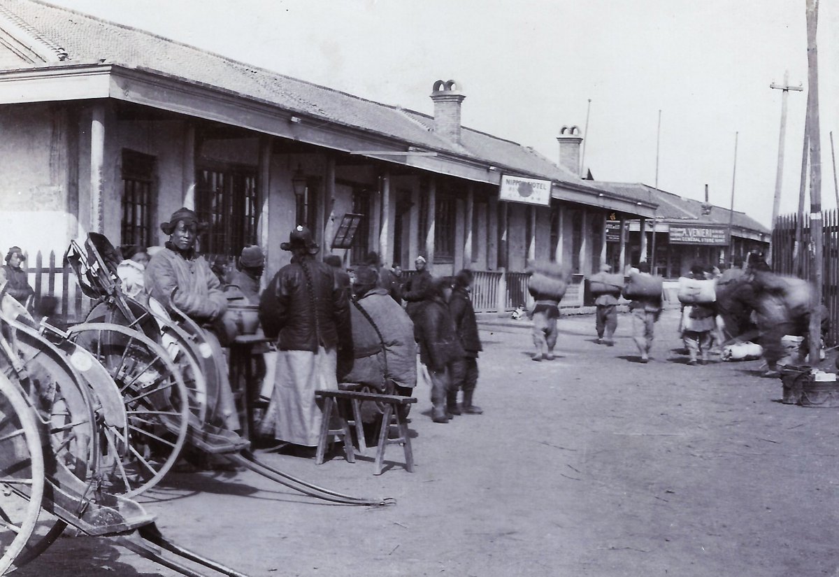 A rickshaw awaits in a street scene in #Tanggu #塘沽 (Tang-ku), c. 1907, with signs advertising the Nippon Hotel and the A. Venieri General Store, from a German military album. #China #中国