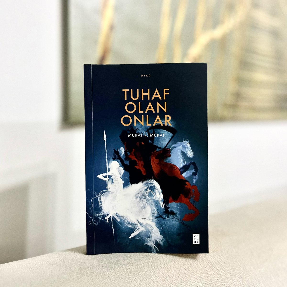 Murat k. Murat, Tuhaf Olan Onlar’da, zaman içinde başka bir zaman, dünya içinde başka bir dünya, hikâye içinde başka bir hikâye inşa ediyor ve zamanlararası bağlarla inşa ettiği kurmaca dünyasına adım atan okurlara şöyle fısıldıyor: “Merak etmeyin, tuhaf olan onlar.”