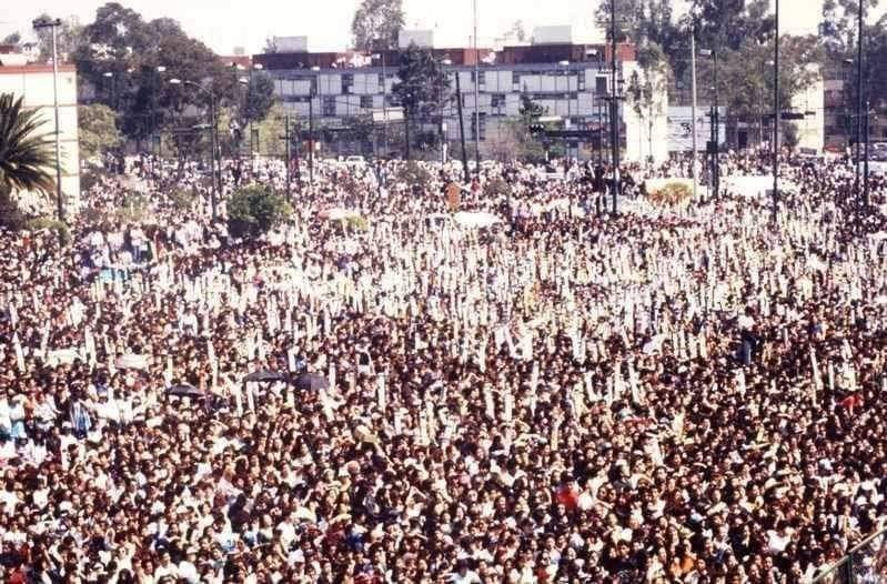 RenegadoRadio's tweet photo. Se cumplen 28 años del concierto de #Caifanes en la Explanada de la Delegación Venustiano Carranza.

"Organizado por Grupo Radio Centro, el concierto de Caifanes se anunció por estaciones de radio como 97.7, se subrayó que sería gratuito, por lo que se esperaba una afluencia mayor a los cuatro precedentes.

Caifanes estaba en su apogeo, las canciones de su disco "El Nervio del Volcán" eran tema generacional, meses antes habían sido teloneros de los Rolling Stones en el Foro Sol, sus conciertos aseguraban llenos, pero los precios eran prohibitivos para una gran mayoría de jóvenes desempleados o que vivían las carencias de la crisis del 94. Para asegurarse un lugar en primera fila, fanáticos del grupo se instalaron desde la noche del sábado en la explanada, muchos otros llegaron a primera hora del día y otros más tres horas previas a lo anunciado.

Programado para las doce del día, el concierto inició una hora antes, esto debido a las protestas del público que ante el calor agobiante exigía la presencia del grupo de rock. Para este momento, la asistencia se calculó en 40 mil personas. Caifanes salió al escenario y abrió con "¿Será por eso?", Saúl Hernández usaba un pantalón estampado como piel de leopardo. La muchedumbre entonó la canción bajo un sol de justicia. Le siguió "Aquí no es así" y "Los dioses ocultos". Los vendedores ambulantes hicieron su agosto, ofrecían: gorras, posters, botones, fotografías del grupo, refrescos, tortas, paletas, tacos y aguas frescas. Las tiendas de los alrededores vendieron cervezas, dos stands de las refresqueras de cola también ofrecieron sus productos en botella de vidrio.

Después se tocó "Pero nunca me caí", grupos de jóvenes llegaban caminando por la avenida Francisco del Paso y Troncoso y generaban caos vial, pues las autoridades delegacionales no cerraron la circulación. 

El grupo continuó con "El comunicador", la multitud saltaba, apretaba, empujaba y se sofocaba. Los bomberos aparecieron y lanzaron chorros de agua, jovencitas se insolaron y desmayaron. Enseguida tocaron "No dejes que..." y "Estás dormida", mientras los jóvenes recién llegados empujaban y se arremolinaban en un intento de adelantar lugares. Otros buscaron sofocar el calor bebiendo cerveza.

También cantaron "Miedo", "Piedra", "La célula que explota", pero para estos momentos el concierto se tornó peligroso. Una valla ciclónica cayó sobre la multitud lesionando a varios jóvenes, los seguidores seguían llegando y algunos exaltados comenzaron a lanzar las botellas de cerveza y de refresco al escenario, pero la mayoría le cayó al público de las primeras filas, descalabrando y contusionando a cerca de 80 personas. El vocalista pedía calma a la asistencia. Ante el desorden y como en el 2 de octubre, dos helicópteros de la Secretaria de Seguridad Pública sobrevolaron la zona, un refuerzo de 200 granaderos apareció ante las rechiflas de los jóvenes. "Cuéntame tu vida" y "Nubes" fue la música de esas acciones.

Caifanes cerró con "Afuera". Por su parte, los socorristas del ERUM y de la Cruz Roja no se dieron abasto ante los lesionados y desmayados.

Saúl Hernández se despidió con un: "gracias, adiós raza". La rechifla fue general y el clásico: "otra, otra" se dejó escuchar. El grupo regresó y entonó "Viento". Al dar por terminado el concierto a las 12: 30, la multitud respondió con el más clásico: "Culeros", "Culeros". La lluvia de botellas de vidrio se intensificó, la multitud formó grupos y los más radicales buscaron bronca a la policía. Un grupo encontró la camioneta del Grupo Radio Centro, que transmitió el concierto en vivo. Los jóvenes le lanzaron piedras, la golpearon, la voltearon, desvalijaron y quemaron. Lo mismo le sucedió a tres patrullas de la policía, aunque la turba no pudo incendiar dos de ellas. Desde el helicóptero se lanzaron bombas lacrimógenas, algunos detuvieron un camión de tabiques y con ellos apedrearon a los vehículos que transitaban por las avenidas circundantes.

Con los tabiques, la banda también destruyó un banco cercano, saquearon comercios y causaron daños a vehículos particulares. Fuertes en número, jóvenes y granaderos se enfrentaron a pedradas en las zonas aledañas. Replegados, los revoltosos siguieron causando destrozos, mientras la autoridad golpeó y robó a los detenidos. Finalmente se consignó a 17 hombres de los 107 encarcelados originalmente. El gobierno del Departamento del Distrito Federal anunció la prohibición de conciertos gratuitos al aire libre. Radio Centro y la Delegación Venustiano Carranza también avisaron de la cancelación del concierto de Bronco, programado para el siguiente domingo. En rueda de prensa, el delegado culpó a jóvenes de Iztapalapa y Ciudad Nezahualcóyotl como los responsables y a Caifanes por tocar poco tiempo".

¿Quién estuvo?