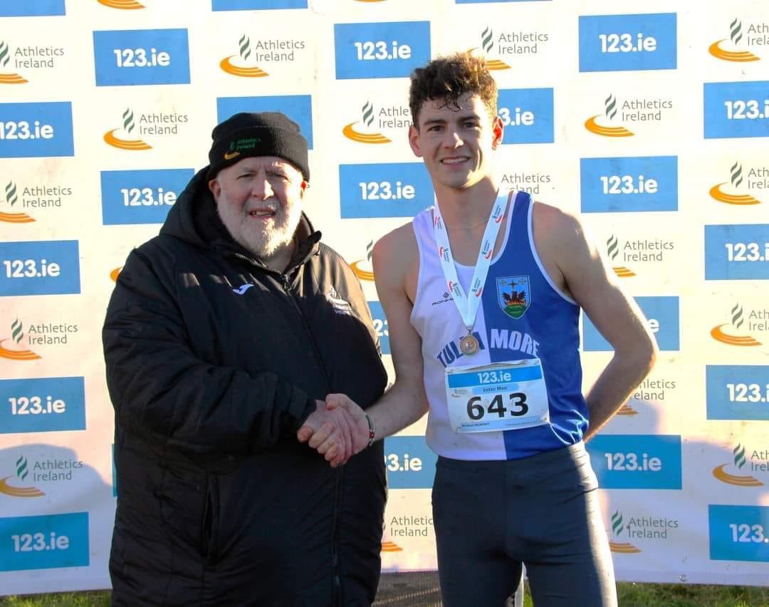 Michael Murphy being congratulated by Mr John Cronin President of Athletics Ireland following his performance at the National Intermediate Cross Country Championships.