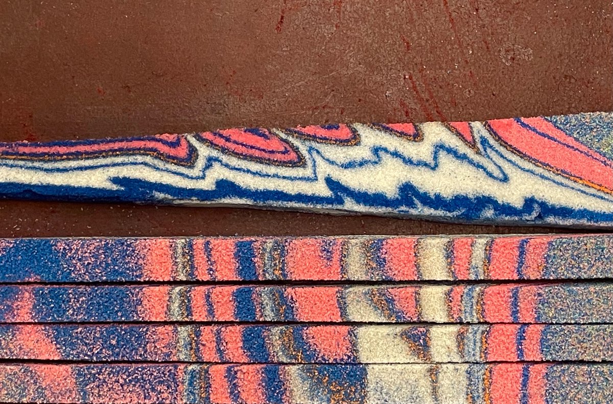 Blind thrust and subtle surface anticline at the front of this sandbox model thrust belt. It’s part of a take-apart geologic map block model with a pink-white anticline-syncline pattern. Thickening of the white layers at the rear of the wedge is impressive.