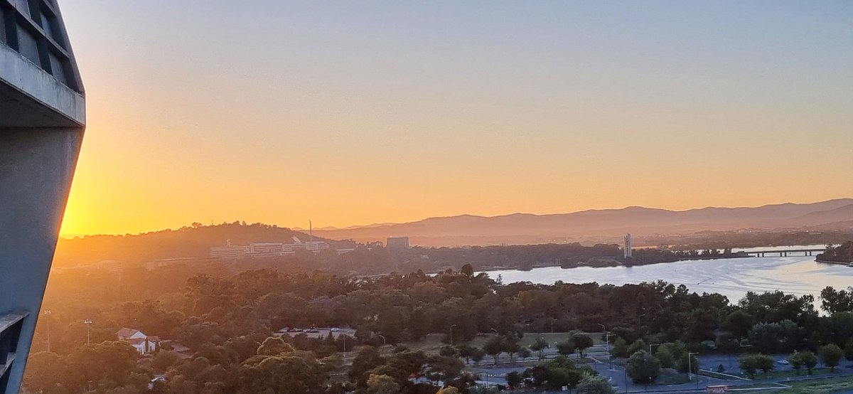 Sunrise over #LakeBurleyGriffin. The light reflection has turned the big flagpole into a gold pillar representing Mammon. #CBR #Auspol