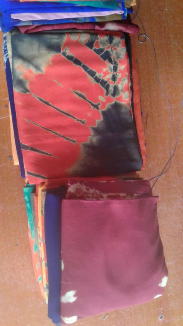 dinowsey's tweet photo. ICDO Mandera Basic Skills and Production Centre. Several women hold pieces of white fabric, intricately tying them in preparation for dyeing. The vulnerable Women and Youth have been participating in a tie-and-dye training from 10th October, 2022. https://t.co/nYLplsPeK0
