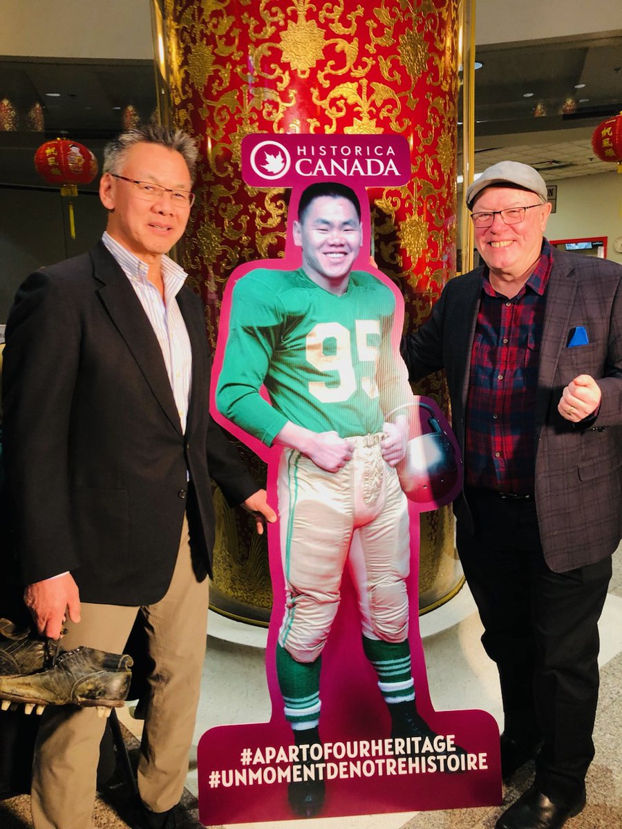 Greg Kwong and I stand beside an image of the great Norm Kwong.  @HistoricaCanada will unveil a #Heritageminute video Tuesday 6.00 AM MT. #heritage #football #yegfootball @GoElks @cfl @calstampeders