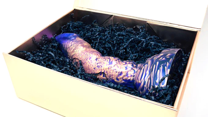 The dildo resting elegantly inside a golden box.