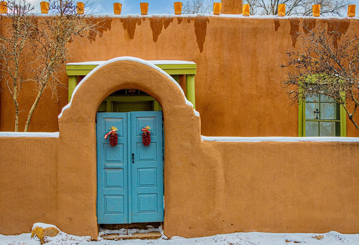 Happy #SantaFeDoorways Tuesday!
Chile ristras on the door, an arched adobe portal dusty with snow, and farolitos on the roof. A quintessential Winter Santa Fe scene.

📸 @katie.stolpestad