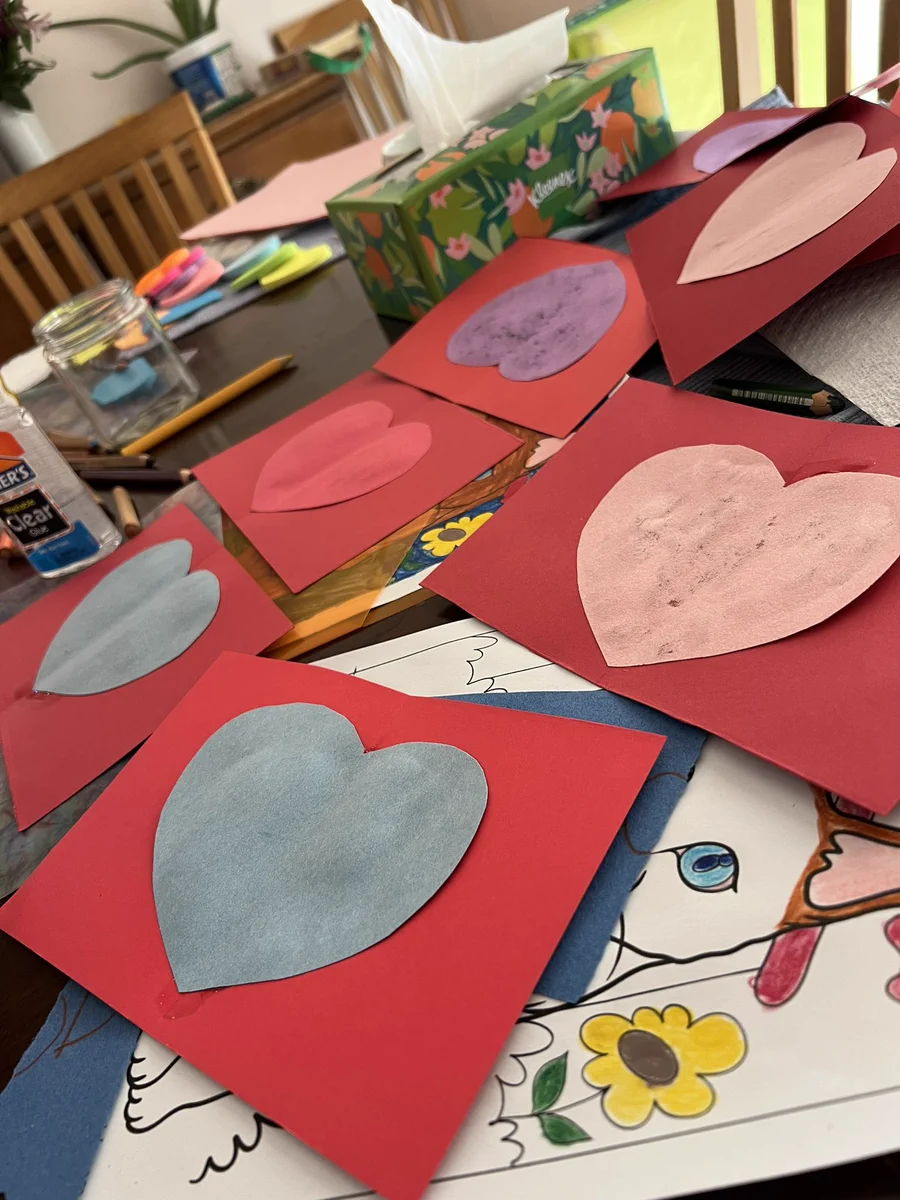 a bunch of handmade valentines day cards in progress haphazardly strewn on a table