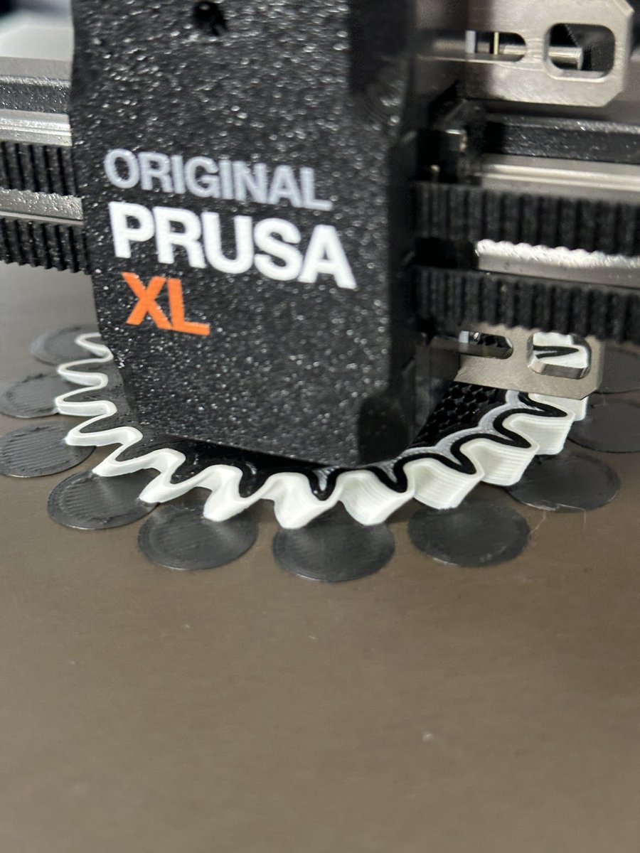 Aaaaand @josefprusa was right again. The #PrusaXL printing a PLA helical gear with PC-ABS outer surface using the Interface shells option on #prusaslicer The helper disks are there out of an abundance of caution, one daredevil test at a time.