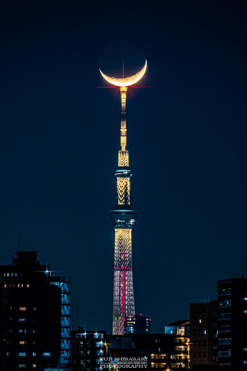 バレンタインライトアップのスカイツリーに三日月が乗る。