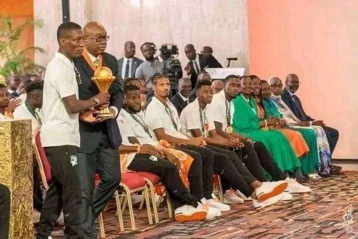 LucaVaran's tweet photo. Le journaliste Andre Silver Konan  :

'' Même au Nigeria, le président de la fédération n'a pas cherché à s'incruster à la place du coach. Prenez toutes les photos officielles de toutes les équipes victorieuses de la CAN depuis toujours. Vous ne verrez aucun président de fédération se faire filmer en train de remettre la coupe à la place du coach et poser à droite du chef de l'Etat, à la place, soit du capitaine, soit de l'entraîneur.

cela s'appelle le complexe de l'omniprésence, qui cache elle-même le complexe de celui qui veut prouver qu'il n'a pas honte d'une situation, alors que dans son for intérieur, il sait que c'est le cas.''