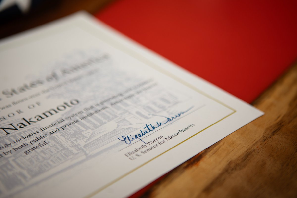 BitcoinMagazine's tweet photo. Elizabeth Warren signed a certificate to honor #Bitcoin creator Satoshi Nakamoto with a ceremonial flag 🇺🇸

"For the 15th anniversary of Bitcoin, the first truly inclusive financial system" 👏 https://t.co/ZemYrn0AV4