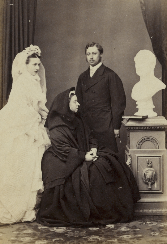 As wedding pictures go it doesn't get much better than Queen Victoria insisting on photobombing her son and his wife, by sitting between them wearing full mourning dress and staring at a bust of her dead husband