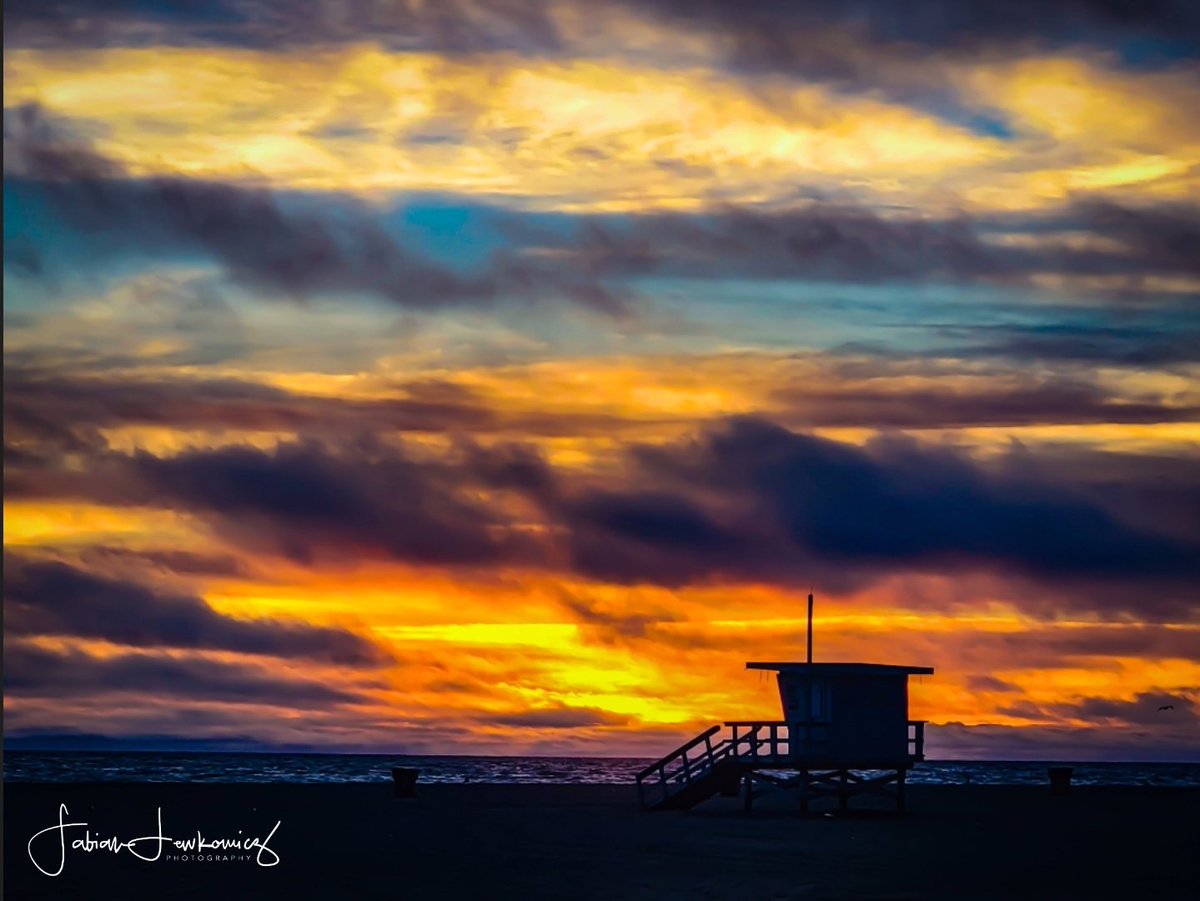 smcloseup's tweet photo. Thursday's sunset at Santa Monica Beach offered a dramatic display of gold and crimson hues, casting a serene glow over the solitary lifeguard station. A tranquil close to the day along the coast. #SantaMonicaBeach #SunsetWatch #ThursdayVibes https://t.co/16KtDnW0Bp