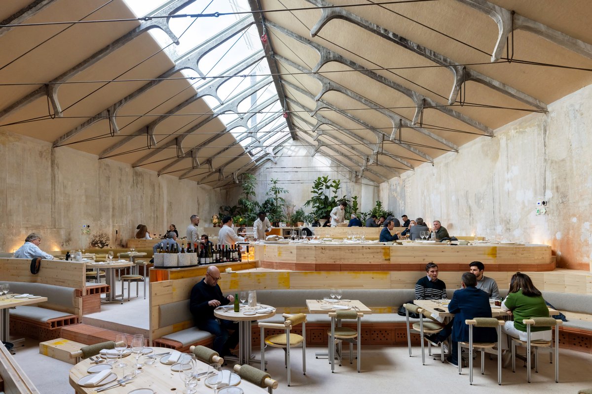 arquitect_viva's tweet photo. Restaurante Tramo en Madrid
Selgascano
https://t.co/ZI0J19v5dU
El proyecto transforma una antigua nave industrial, de principios de la década de 1950, en un restaurante. La construcción que albergaba un taller mecánico y el bar Garaje Hermético, icono de la noche madrileña, conserva tras la rehabilitación la sencillez y la belleza de la estructura de la cubierta, formada por esbeltas cerchas de hormigón y cables de acero. La climatización se lleva bajo los bancos corridos que forman los propios conductos cerámicos, dejando salir el aire por orificios abiertos irregularmente bajo los comensales, a modo de plénum. Las más de mil piezas cerámicas, fabricadas artesanalmente y moldeadas por extrusión, contienen un sistema de calefacción y refrigeración natural que canalizan térmicamente el aire del exterior.