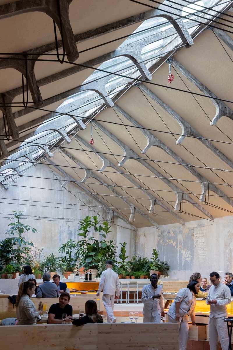 arquitect_viva's tweet photo. Restaurante Tramo en Madrid
Selgascano
https://t.co/ZI0J19v5dU
El proyecto transforma una antigua nave industrial, de principios de la década de 1950, en un restaurante. La construcción que albergaba un taller mecánico y el bar Garaje Hermético, icono de la noche madrileña, conserva tras la rehabilitación la sencillez y la belleza de la estructura de la cubierta, formada por esbeltas cerchas de hormigón y cables de acero. La climatización se lleva bajo los bancos corridos que forman los propios conductos cerámicos, dejando salir el aire por orificios abiertos irregularmente bajo los comensales, a modo de plénum. Las más de mil piezas cerámicas, fabricadas artesanalmente y moldeadas por extrusión, contienen un sistema de calefacción y refrigeración natural que canalizan térmicamente el aire del exterior.