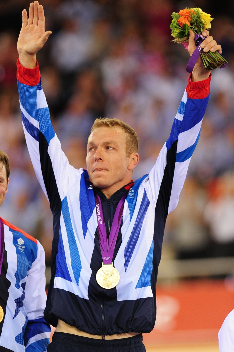 Sir Chris Hoy with his hands aloft on the podium after winning men's team sprint gold at the London 2012 Olympics