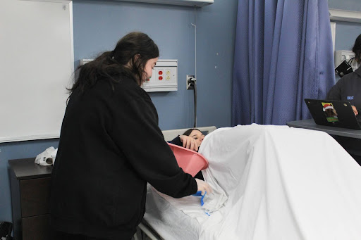 One of the skills performed was bedpan management. The importance of the bedpan management is to care for patients with infections while providing a high level of care. As you can see from this image, the student is preparing to place the bedpan under the patient.