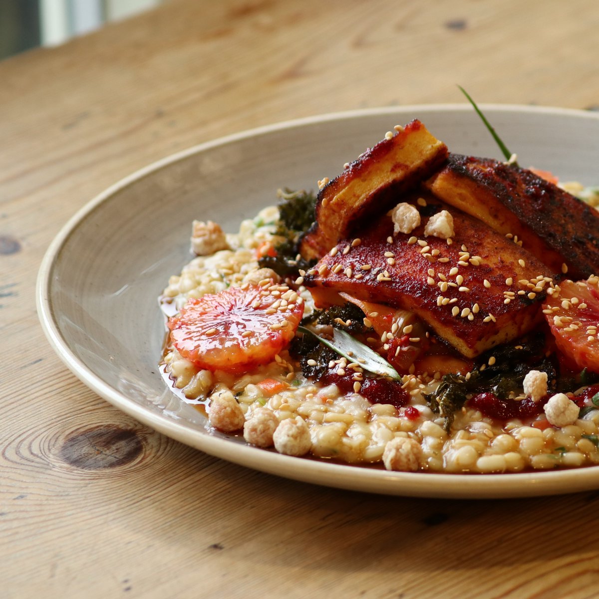 C H I C K P E A T O F U 🌱 This Korean vibed is centered around chickpea tofu that we make using @Hodmedods Norfolk grown chickpea (gram) flour. With naked oat yachae jook, swede and celeriac kimchi, yangnyeom jang sauce, blood orange, crispy chickpeas, kale and sesame.