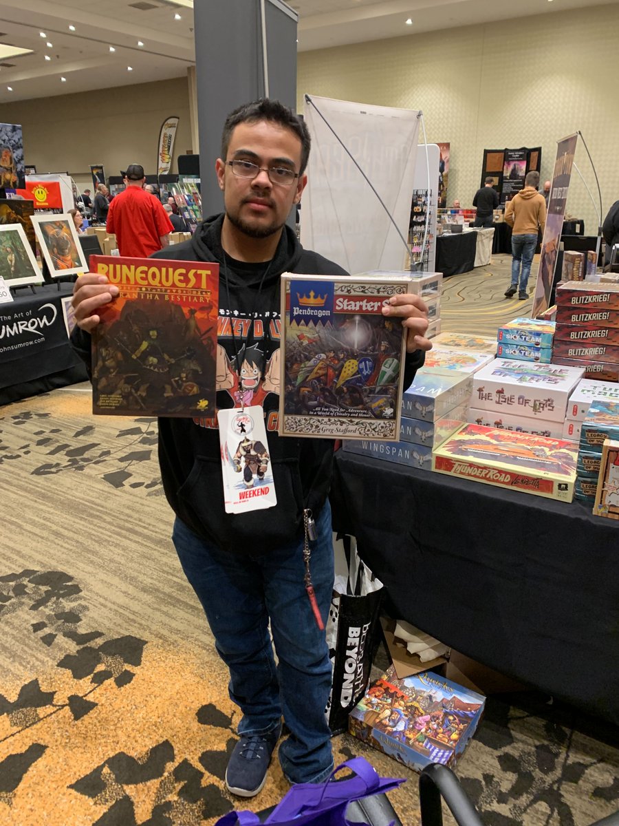 Chaosium_Inc's tweet photo. The Exhibit Hall is open at #GenghisCon in Denver CO! And our first purchaser is Ngawati, who has picked up copies of the #RuneQuest Bestiary and the #Pendragon Starter Set. Come and say hi to Jeff and Rick! https://t.co/uxxVrY0ad9