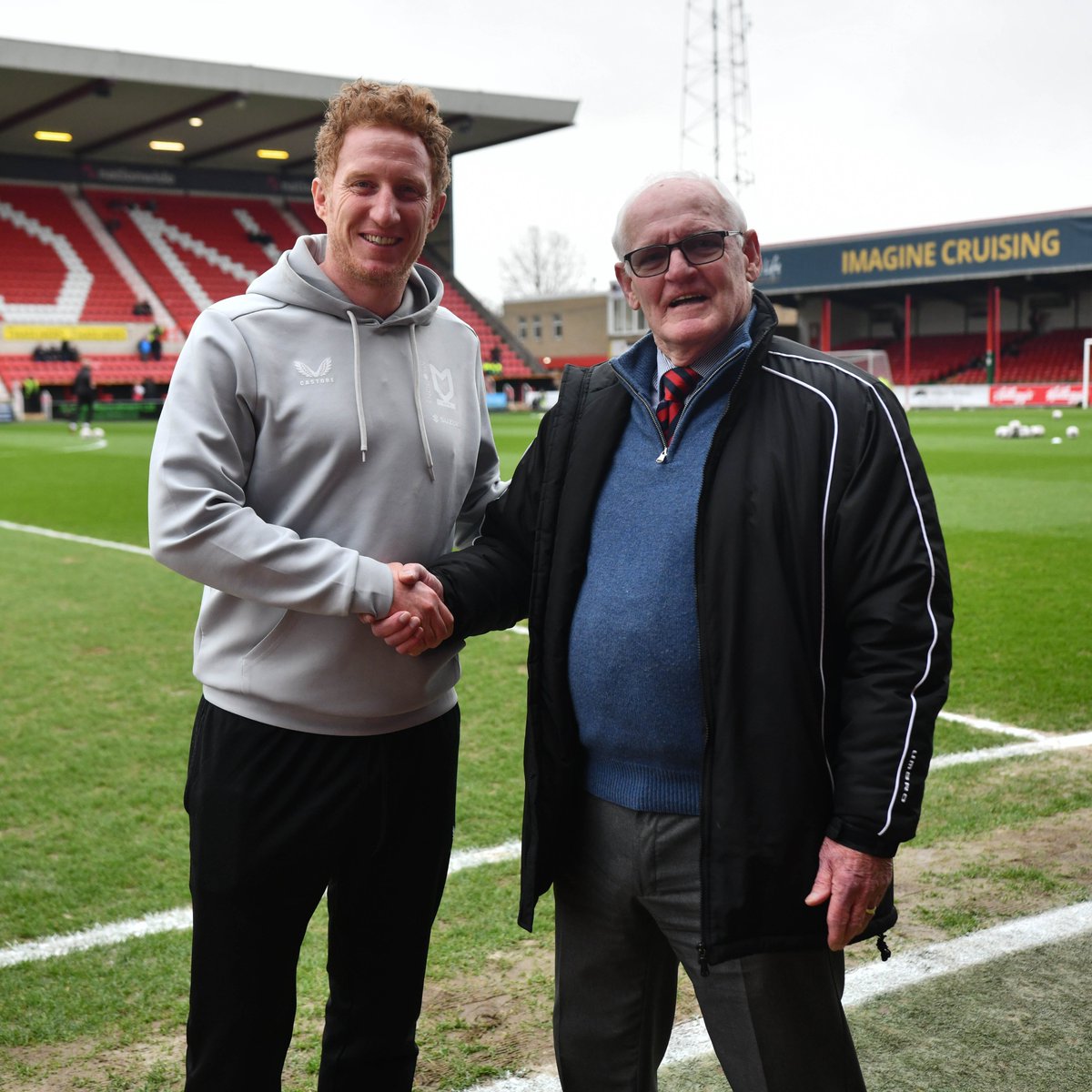 Official_STFC's tweet photo. Dean Lewington 🤝 John Trollope 

📸 #STFC Legend John Trollope posing for a photo with @MKDonsFC's Dean Lewington who broke John's long-standing achievement for most league appearances for a single @EFL Club recently. https://t.co/BhQpFMnkr1