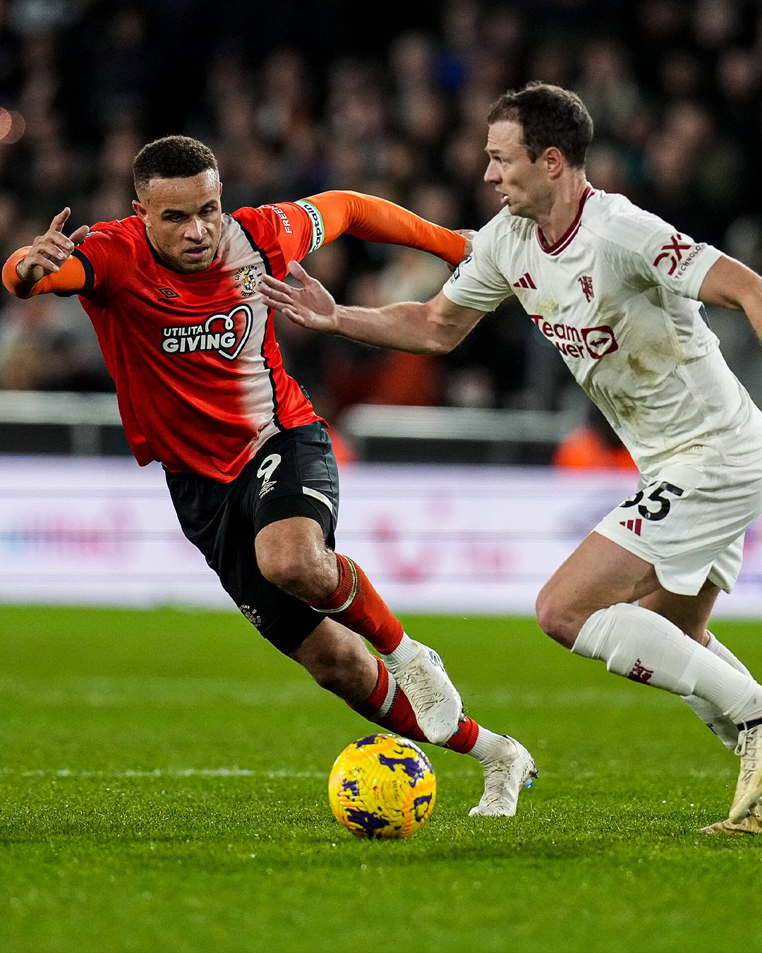 Carlton Morris chasing down Jonny Evans.