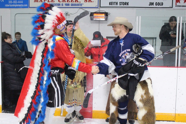 CraigBaird's tweet photo. Yesterday in Maple Creek SK, the Battle of Little Big Puck took place.

It is an annual hockey game between local ranchers and the Nekaneet First Nation that dates back 45 years.

So, let's learn more!

According to legend, the hockey game dates back to a hot day in July in the 1970s when a couple of local ranchers and local members of the Nekaneet First Nation were in the Commercial Hotel having a beer together. 

They began to joke with each other as to who could ride the toughest horses, rope the quickest and more. Finally, the conversation turned to hockey and who would win on the ice. From there, the Battle of Little Big Puck was born.

The name comes from the Battle of Little Big Horn. Following the defeat of General Custer, Sitting Bull and 5,000 Lakotas came into Canada to find refuge in southern Saskatchewan. They would remain for several years until they were starved into returning to the United States by the Canadian government.

One interesting aspect of the game is that for the third period, the players dress in cowboy gear and Indigenous regalia, including cowboy hats, chaps, feathers, face paint and beads. A local constable with the RCMP referees the game. The RCMP officer changes into a red coat and Stetson for the third period.

The game is played for charity, raising thousands of dollars every year for worthy causes in the community.

If you enjoy my Canadian history content, you can support it with a donation at https://t.co/u12Dmz7XUX

****
Hier à Maple Creek SK, la bataille de Little Big Puck a eu lieu.

Il s'agit d'un match de hockey annuel entre les éleveurs locaux et la Première Nation de Nekaneet qui remonte à 45 ans.

Alors, apprenons-en davantage !

Selon la légende, le match de hockey remonte à une chaude journée de juillet dans les années 1970, lorsque deux éleveurs locaux et des membres locaux de la Première nation Nekaneet se trouvaient à l'hôtel commercial en train de prendre une bière ensemble.

Ils ont commencé à plaisanter entre eux sur la question de savoir qui serait capable de monter les chevaux les plus coriaces, de faire de la corde le plus rapidement et plus encore. Finalement, la conversation s'est tournée vers le hockey et vers qui gagnerait sur la glace. De là est née la bataille de Little Big Puck.

Le nom vient de la bataille de Little Big Horn. Après la défaite du général Custer, Sitting Bull et 5 000 Lakotas sont venus au Canada pour trouver refuge dans le sud de la Saskatchewan. Ils y resteront plusieurs années jusqu'à ce que le gouvernement canadien les oblige à retourner aux États-Unis.

Un aspect intéressant du jeu est que pendant la troisième période, les joueurs portent des vêtements de cowboy et des insignes autochtones, notamment des chapeaux de cowboy, des jambières, des plumes, de la peinture pour le visage et des perles. Un agent local de la GRC arbitre le match. L'agent de la GRC enfile un manteau rouge et Stetson pour la troisième période.

Le jeu est joué à des fins caritatives, collectant des milliers de dollars chaque année pour de bonnes causes dans la communauté.

Si vous appréciez mon contenu sur l'histoire canadienne, vous pouvez le soutenir avec un don à https://t.co/u12Dmz7XUX