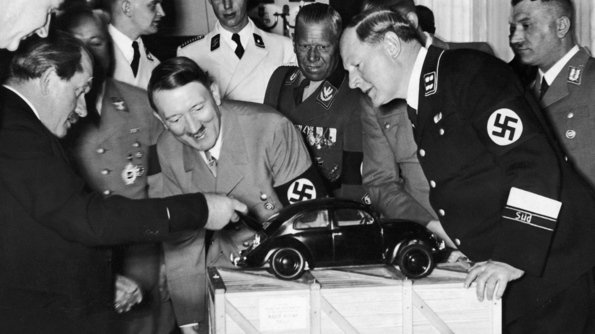 Adolf Hitler being shown the Volkswagen.
