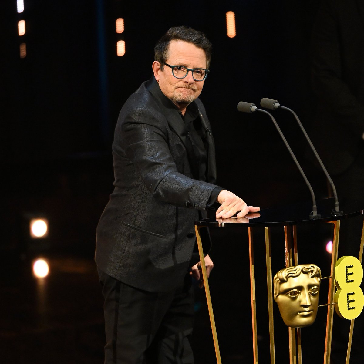Michael J. Fox stands at the podium to present the Best Film Award on stage during the EE BAFTA Film Awards 2024 at The Royal Festival Hall on February 18, 2024 in London, England.