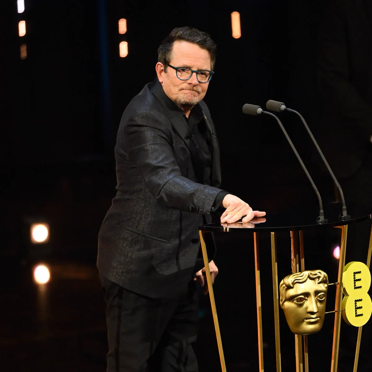 Michael J. Fox stands at the podium to present the Best Film Award on stage during the EE BAFTA Film Awards 2024 at The Royal Festival Hall on February 18, 2024 in London, England.
