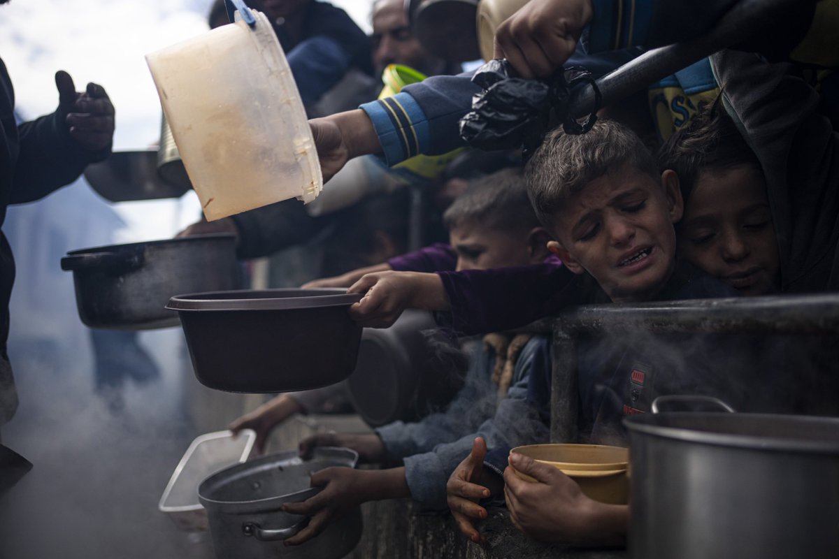 Palestinians line up for a free meal in Rafah, Gaza Strip. International aid agencies say Gaza is suffering from shortages of food, medicine and other basic supplies as a result of the war between Israel and Hamas. (AP Photo/Fatima Shbair)