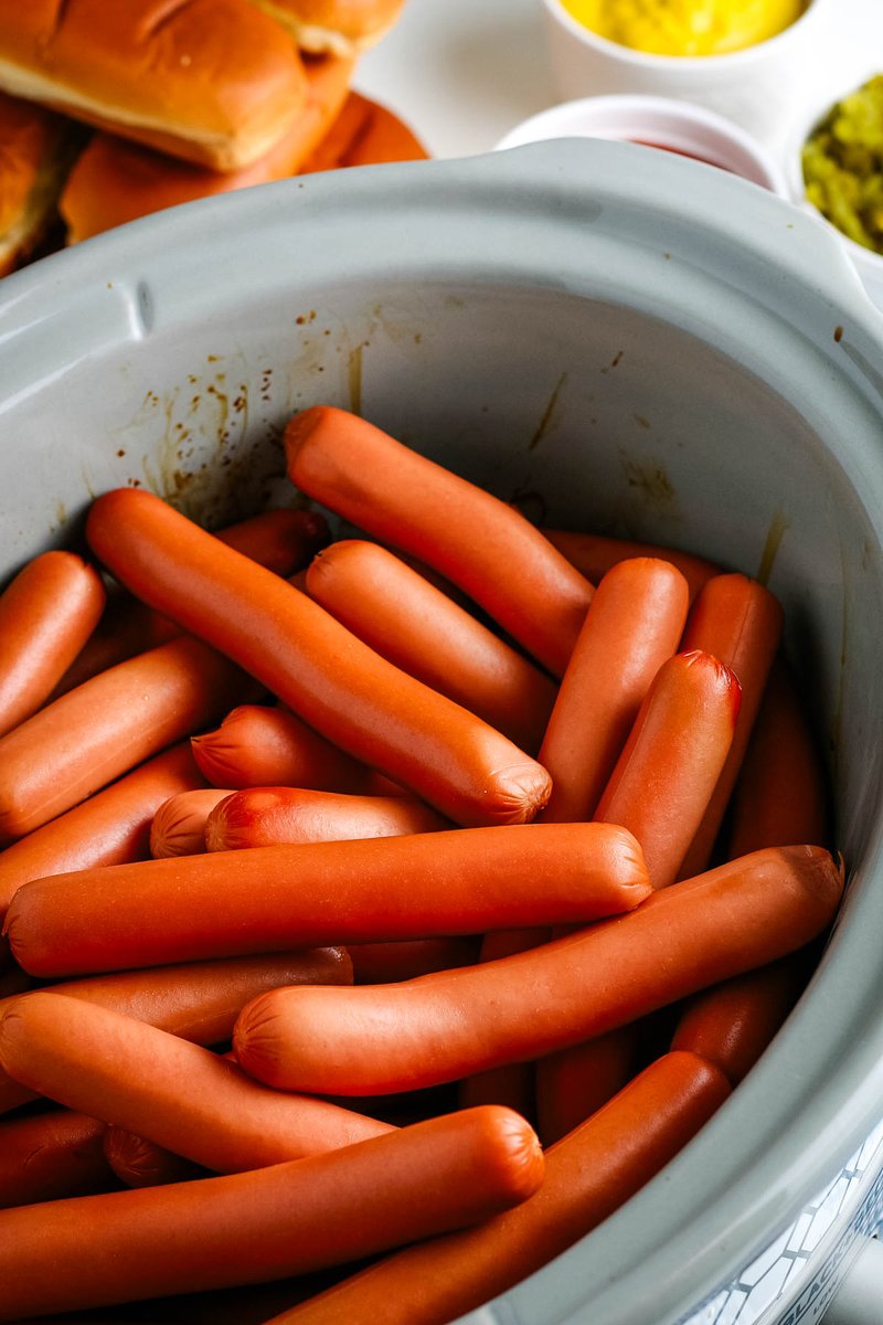 How to cook easy #CrockPot hot dogs with the BEST flavor. Great make-ahead recipe that you can use to set up the ultimate hot dog bar with all of your favorite toppings to serve at your next summer potluck or backyard BBQ! adventuresofmel.com/crock-pot-hot-…
