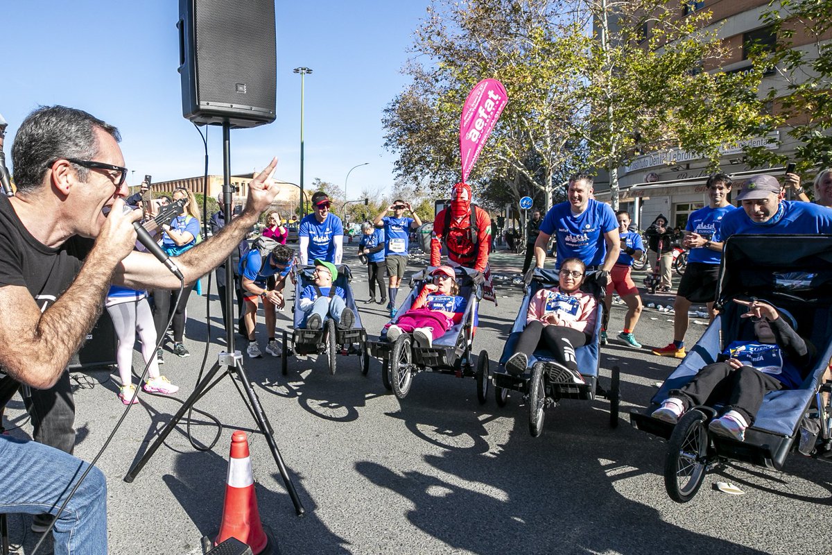 TribunaLibreES's tweet photo. Seis niños y jóvenes con ataxia telangiectasia,

“finishers” ayer del Zurich Maratón de Sevilla 2024

Un grupo de 23 corredores solidarios de distintas comunidades autónomas empujaron ayer las sillas de Carmen y José (de Sevilla), Sara (Madrid), Aaron y Nerea (hermanos de Talavera, Toledo) y Jon (Vitoria-Gasteiz)

El equipo quedó tercero en el podio de causas solidarias de Migranodearena

Seis niños y jóvenes con ataxia telangiectasia cruzaron ayer la meta del Zurich Maratón de Sevilla, tras 42 km de risas, bailes y animación, en sus sillas especiales empujadas por un grupo de 23 corredores solidarios. Su enfermedad aún no tiene cura ni tratamiento, y ellos son conscientes, pero tienen esperanza y luchan con sus familias por la investigación de la ataxia telangiectasia, un tipo minoritario de ataxia.

En Sevilla cumplieron ayer su maratón número 27 para seguir dando a conocer esta enfermedad rara y recaudar fondos para la investigación, en representación de los poco más de 40 casos que se agrupan en España dentro de la asociación Aefat (con cinco casos en Sevilla y más de 10 en toda Andalucía).

Corredores y afectados, procedentes de distintas comunidades autónomas, forman el Equipo Zurich Aefat, una iniciativa de deporte inclusivo creada en 2017 por esta asociación y apoyada por la compañía de seguros, para participar en las cinco grandes maratones que se celebran anualmente en España (Sevilla, Barcelona, Madrid, San Sebastián y Valencia).

Una iniciativa solidaria que sirve también para motivar a los afectados, y para que las familias disfruten de un fin de semana de convivencia en el que compartan alegrías, miedos, dudas y experiencias, tanto con aquellos cuyos sus hijos han fallecido ya, como con los que tienen pequeños que aún caminan o mayores que ya usan silla de ruedas.

Los participantes con ataxia telangiectasia, con edades entre 11 y 23 años, fueron finalmente Carmen y José (de Sevilla), Sara (Madrid), Jon (Vitoria-Gasteiz), y los hermanos Aaron y Nerea (Talavera de la Reina, Toledo). En Sevilla se dieron cita también otras familias con niños y jóvenes con ataxia telangiectasia, como Ana y Emma, de Sevilla, o Inma, de Madrid.

Un equipo de 23 corredores solidarios, procedentes de Andalucía, Canarias, Valencia, Madrid, País Vasco, Cataluña, Aragón y Extremadura, empujaron sus sillas en Sevilla. SpiderAbel, atleta de Amurrio (Álava) que lleva más de 100 maratones corriendo disfrazado de Spiderman, es el abanderado fijo del equipo. En sus camisetas azules lucieron el lema “Corre, frena la AT” de Aefat.