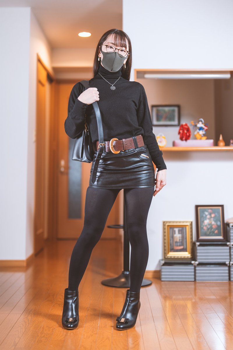 黒のニットトップスにフェイクレザーのタイトミニスカートと透けない黒タイツとショートブーツの組み合わせの写真です。
