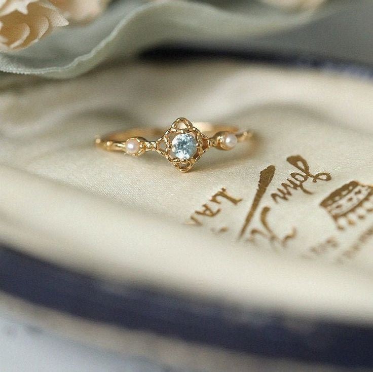 <a href="/bllumflc/">lya</a> ——Un anillo descansaba en el interior de la pequeña caja, fino y delicado, como la muchacha que iba a portarlo.

Era dorado, decorado en su centro con un brillante topacio turquesa y dos perlas blanquecinas hacia sus costados, como guardianes que custodiaban la promesa que ese ›