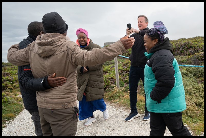 Photo du Jour: Foreign Secretary Lord David Cameron meets a Zimbabwean de-mining team at Gypsy Cove on the Falkland Islands where they now live. By Stefan Rousseau/PA