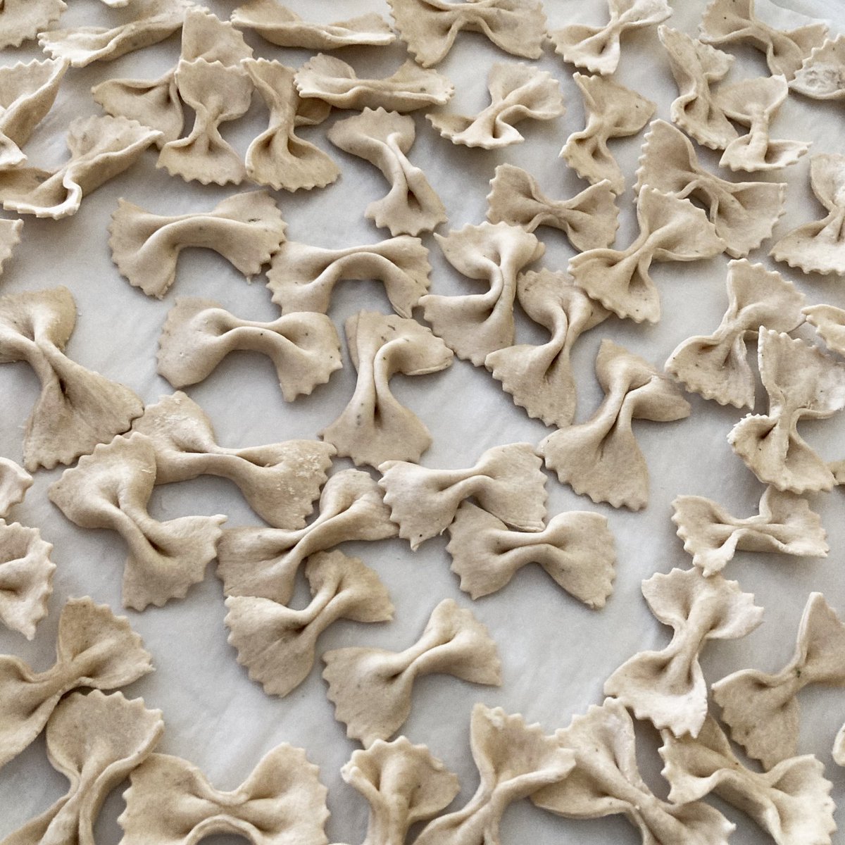 Tuscan herb infused homemade farfalle. Made a bit thicker than usual because I'm shipping it and don't want too much breakage along the way. You can tell I was getting tired by this 5th tray because some of them are a bit wonky. 🧑‍🍳 #Italian #Cooking #Pasta