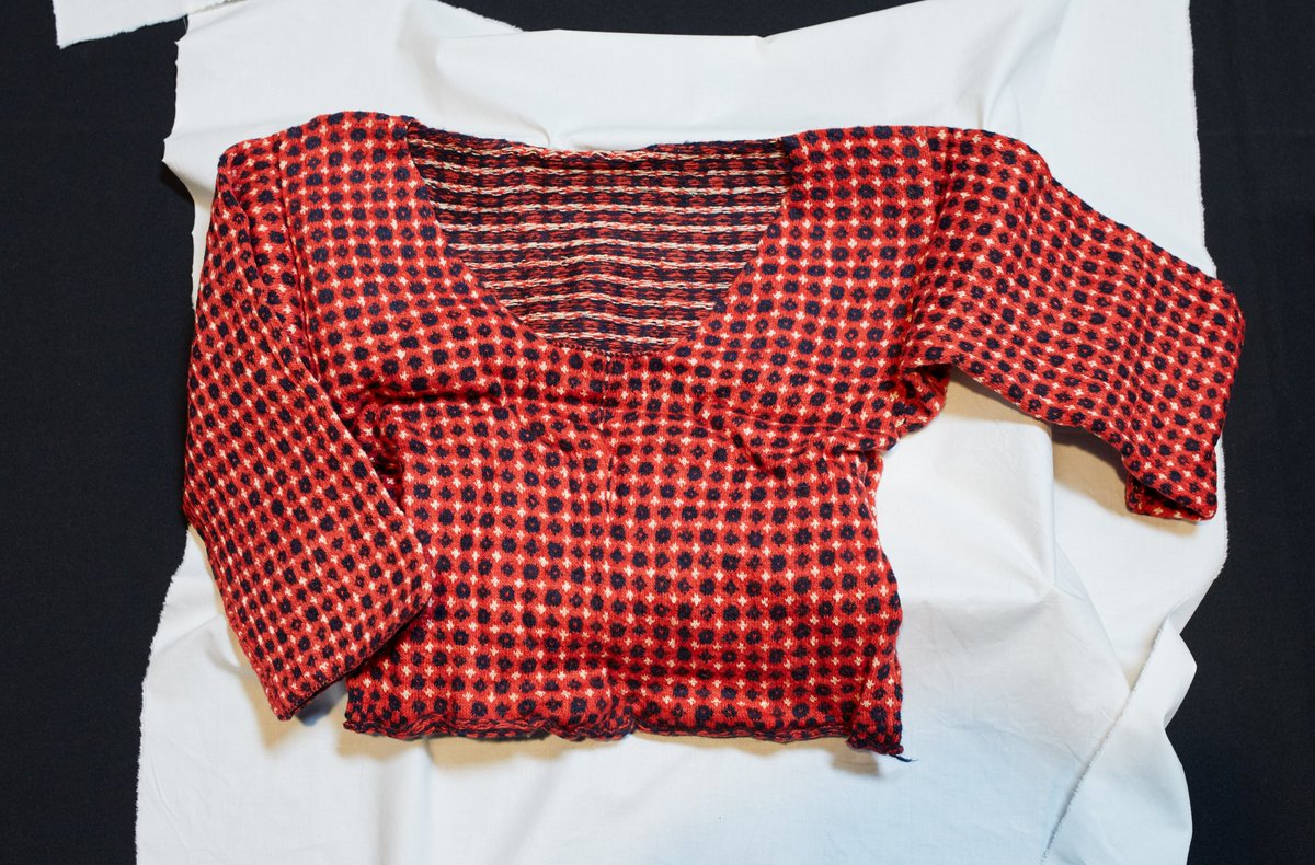 The first package contained a beautiful women’s red knitted jumper. Its stitches are minute and not immediately visible, with the red and navy fabrics being wool and white perhaps cotton. The design is similar to examples worn as part of Faroese national dress today. /3