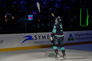 McCann yeeting the fish plushie over the glass towards fans