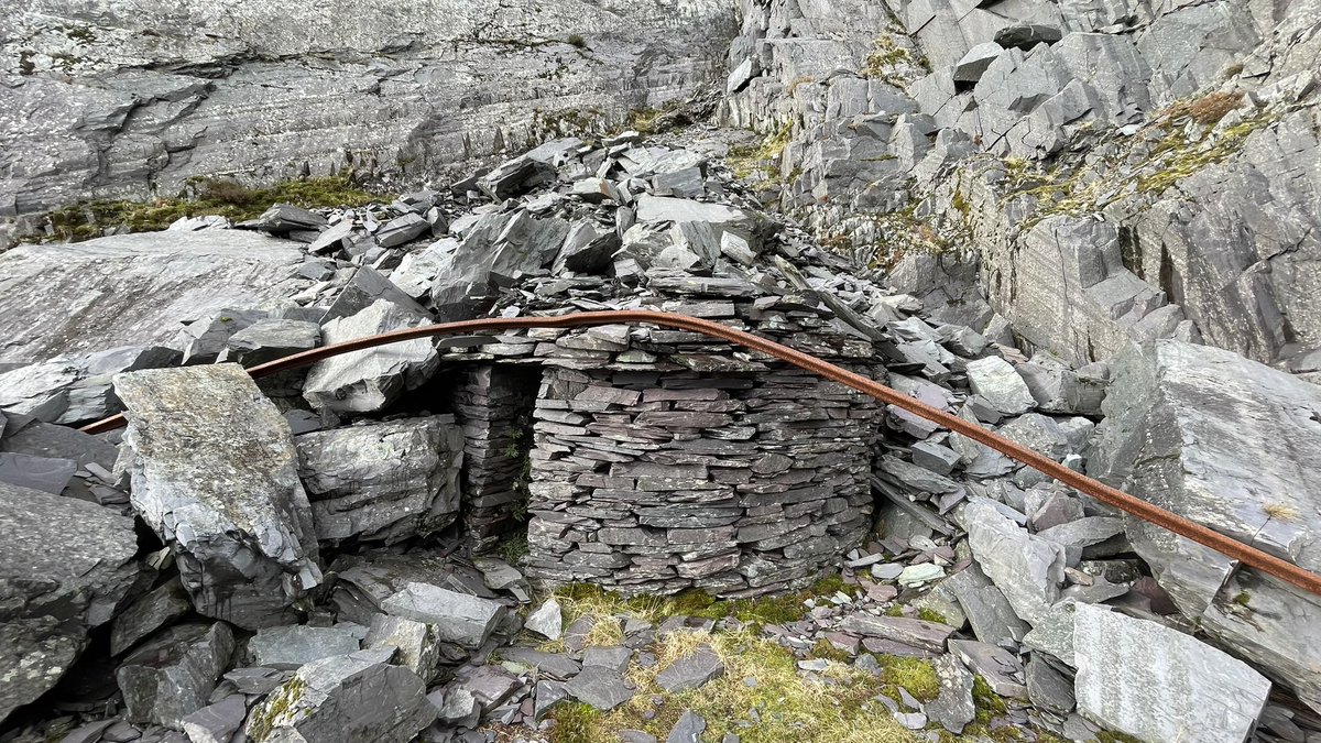 MerlinTomkins's tweet photo. Slate quarry blast shelter Lôn Garet. For hiding in when blasting stone. These round structures have meter thick walls with enough room for about eight men, this one is partially buried by a recent rockfall. If you zoom into the second picture you can see two others. https://t.co/AD3Aq4b9iG