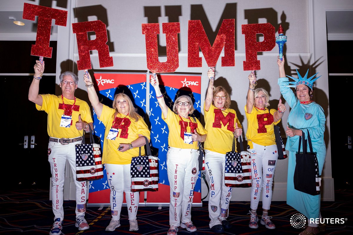 A group of Trump supporters hold up signs at the Conservative Political Action Conference (CPAC) annual meeting in National Harbor, Maryland. Photo by @Moxie_Manda