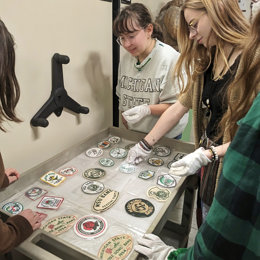 MSUMuseum's tweet photo. See behind the scenes of an exhibit in the making! We visited MSU Museum Collections with the Museum Studies Curatorial Practices class as they examined artifacts for upcoming exhibit, "Marking Time: A Year of Spartan Marching Band Traditions" coming April 19! @MSUMarchingBand https://t.co/Y7DS9meKci