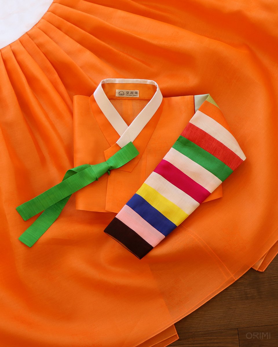 Orimihanbok's tweet photo. 선명하고 경쾌한 색감에 기분이 좋아질 거에요, 주황색 색동한복 🧡

경쾌하기 그지없는 색깔들을 모아서 만든 색동 소매를 단 저고리만 봐도 기분이 즐거워집니다. 가로결이 있는 원단의 초록 고름도 참 예쁘죠? 저고리의 몸판과 치마를 주황색으로 통일해 한층 더 시선이 주목될 수 밖에 없는 한 벌! https://t.co/zppTCP99Qf