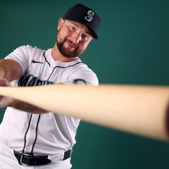 Photo of Cal Raleigh holding his bat at the camera.