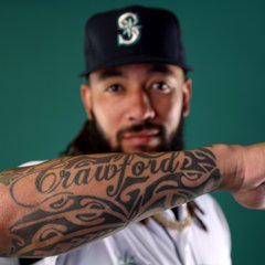 Photo of J.P. Crawford showing off his tattoo of his last name on his forearm.